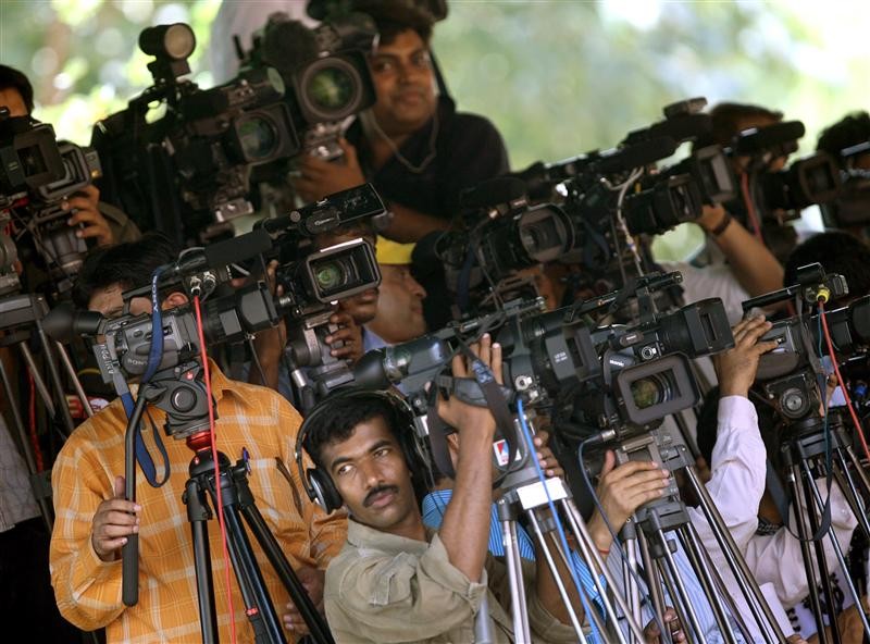 Television cameramen take pictures of India's Prime Minister Manmohan Singh, who is on his way to submit his resignation to President Pratibha Patil at the presidential palace in New Delhi May 18, 2009. The Congress-led coalition eyed possible new allies on Monday after a decisive general election victory raised hopes of a stable government and sent financial markets soaring. REUTERS/Arko Datta (INDIA POLITICS)