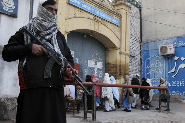 Security guards stand alert around schools and colleges following an attack on Bacha Khan University, in Peshawar, Pakistan, Thursday, Jan. 21, 2016. Pakistanis buried their dead and observed a day of nationwide mourning Thursday following the brazen attack by Islamic militants who stormed a northwestern university the previous day, gunning down students and teachers and spreading terror before the four gunmen were slain by the military. (AP Photo/Mohammad Sajjad)